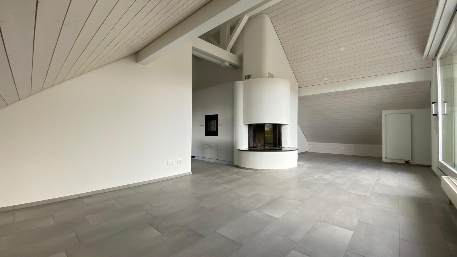 Dachwohnung nach der Sanierung – moderner Wohnraum mit Cheminée und neuem Boden
