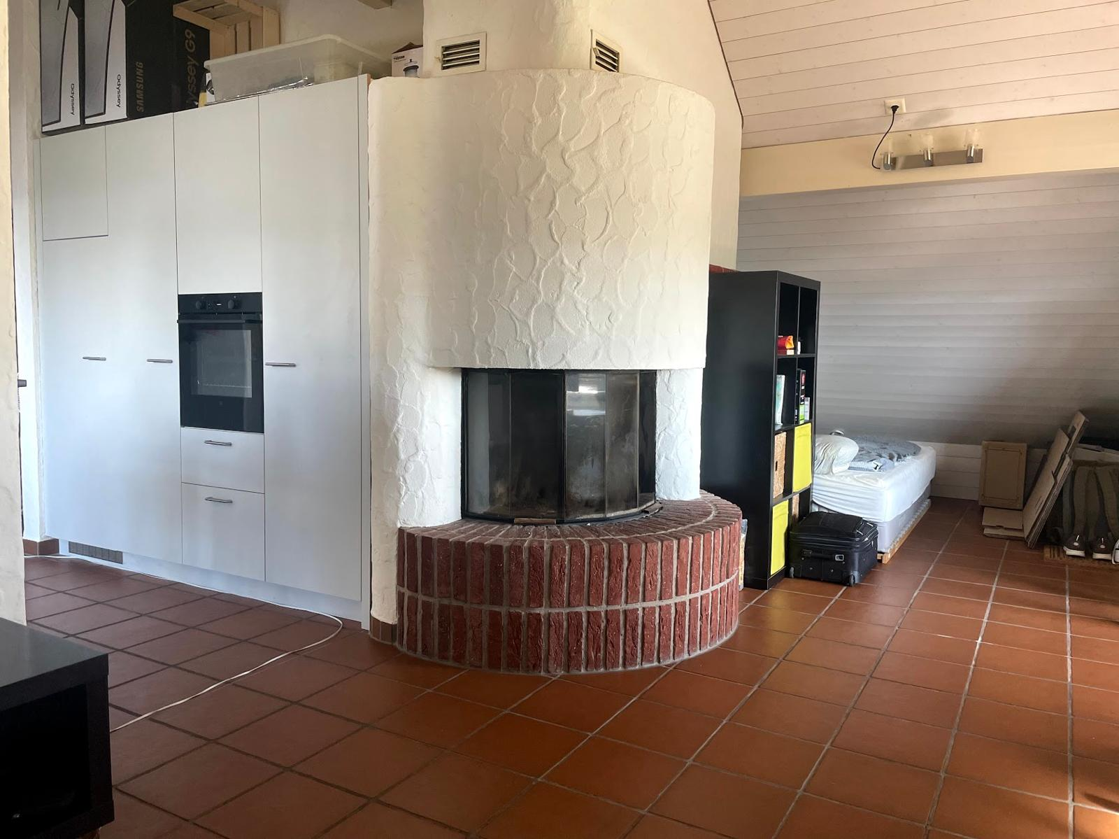 Dachwohnung vor der Sanierung – alter Cheminée-Bereich mit Terracotta-Boden